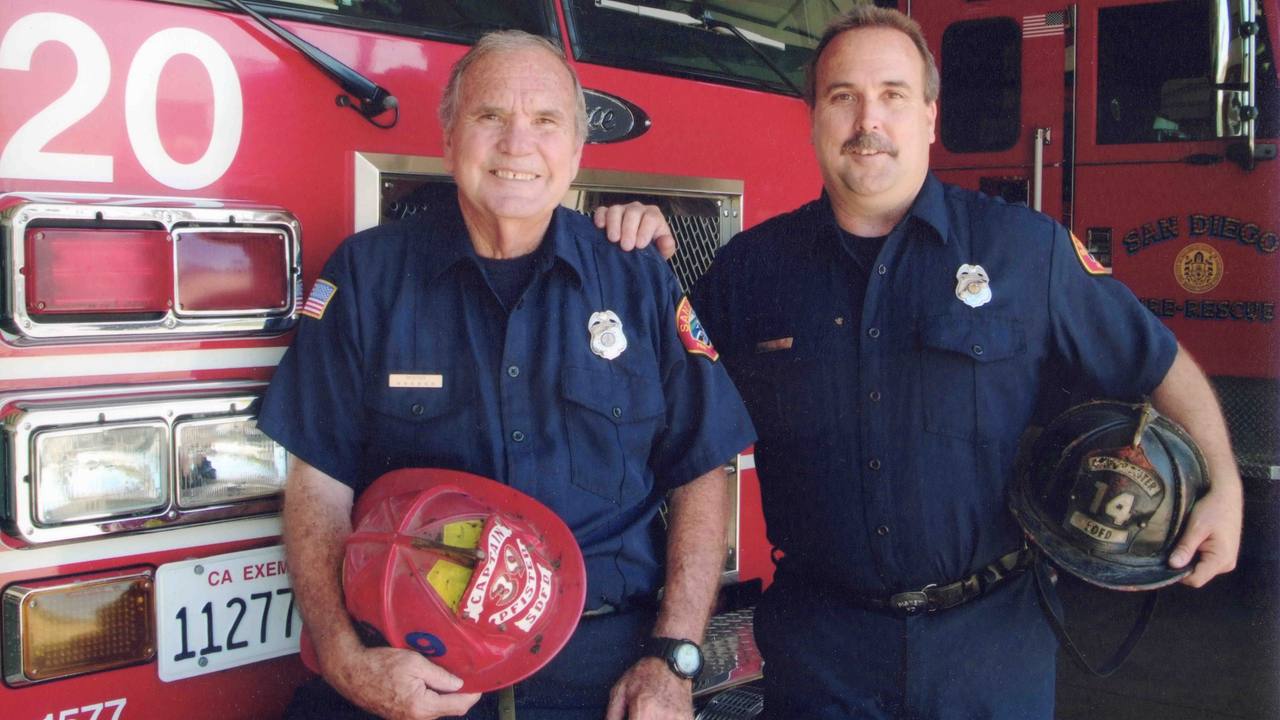 Jim Pfister and his son Jim in uniform, holding William Pfister's helmet.