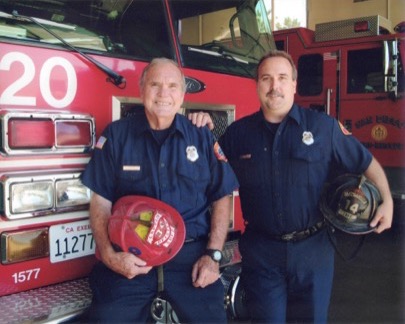 Jim Pfister and his son Jim in uniform, holding William Pfister's helmet.
